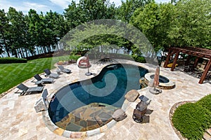 Luxurious outdoor pool in the backyard of a home, overlooking lake