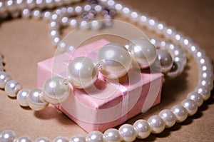 Luxurious pearl jewelry on a pink box. Snow-white pearls. Bijouterie. Jewelry. Pearl beads. Women`s jewelry.