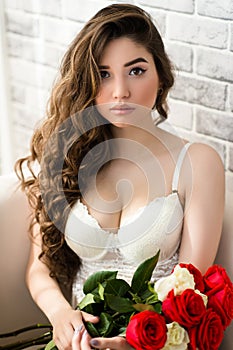 Luxurious portrait sensual woman in white lingerie with bouquet roses in hands