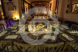 Luxurious romantic party table setting lit by candles, elegant ballroom for wedding reception