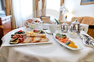 Luxurious Room Service. Close up of breakfast in luxury hotel room delivered by waiter. Hospitality and vacation concept