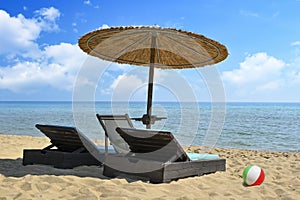 luxurious sunbeds and straw umbrella