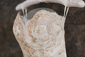 A luxurious wedding dress hangs on a hanger.