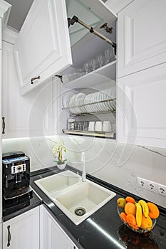 Luxurious white modern kitchen interior, drawers pulled out, doors open