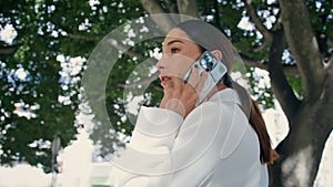 Luxurious woman speaking telephone walking under tree close up. Lady calling