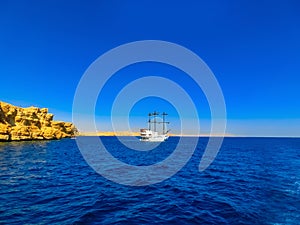 A luxurious wooden sailboat in the Red Sea against the blue sky