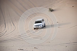 Luxurous white SUW all wheel drive 4x4 on desert safari on dunes exreme racing in arabia travel rally on sand in sports