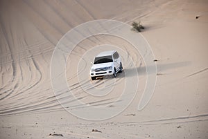 Luxurous white SUW all wheel drive 4x4 on desert safari on dunes exreme racing in arabia travel rally on sand in sports photo