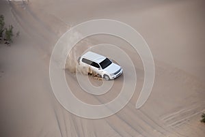 Luxurous white SUW 4x4 on desert safari on dunes exreme racing in arabia travel rally on sand in sports vehicle photo