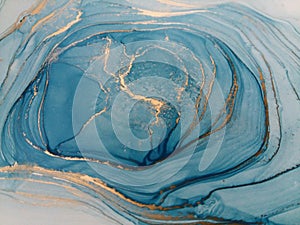 Luxury abstract fluid art painting background alcohol ink technique blue and gold. Swirls of shiny gold edges.