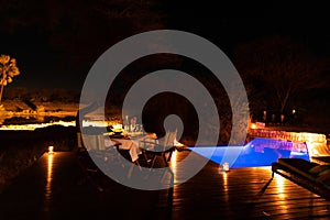 Luxury African Safari lodge outdoor dining in backyard and swimming pool, Namibia.