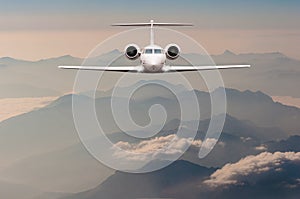 Luxury Airplane fly over clouds and Alps mountain on sunset. Front view of a big passenger or cargo aircraft, business