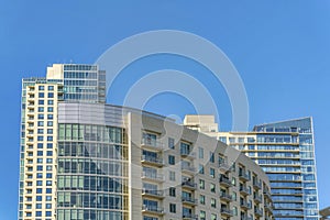 Luxury apartments with glass facade against blue sky background on a sunny day