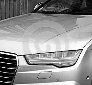 Luxury Audi A8 silver car parked in city car headlight detail