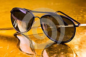 Luxury aviator sunglasses on golden background