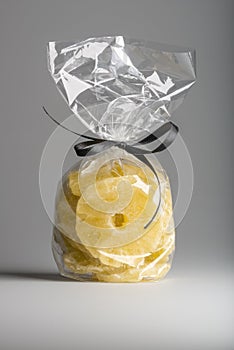 Luxury bag of dried pineapple slices isolated with elegant ribb