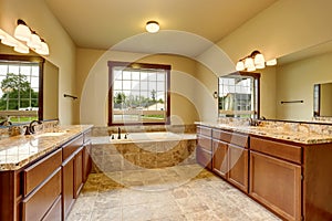 Luxury bathroom interior with granite trim and two vanity cabinets.