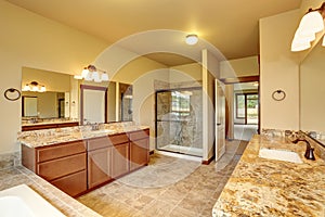 Luxury bathroom interior with granite trim and two vanity cabinets.