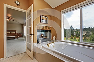 Luxury bathroom interior. Wall mounted fireplace with bath tub