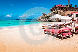 Luxury beach chairs and umbrella on exotic beach in St Barths, Caribbean Island.