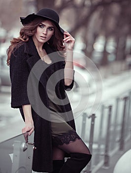 Luxury beautiful woman in black hat, trandy coat and fashion lac