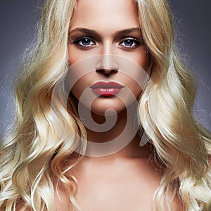 Luxury beautiful young woman with healthy curl blond hair