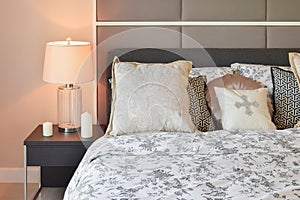 Luxury bedroom with flower pattern pillows and decorative table lamp