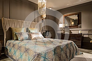 Luxury bedroom interior with carved wood bed, dresser and nights