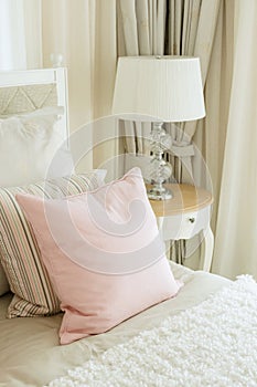 Luxury bedroom interior with pink pillows and reading lamp