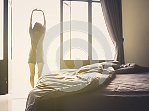 Luxury bedroom and young woman stretching