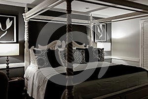 Luxury black and white master bedroom with a four poster bed