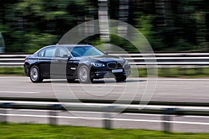 Luxury BMW 750 speeding on empty highway