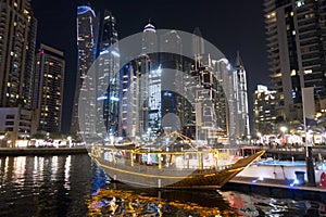 Luxury boats docked in sea port in Dubai Marina, United Arab Emirates during the night