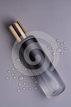 Luxury bottle of toner on gray background. Skincare Product. Toner with peptides. Empty packaging mock up bottle