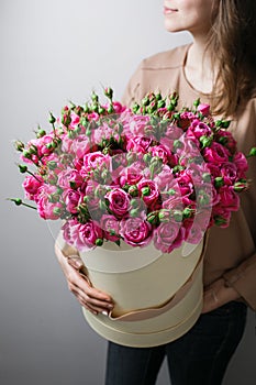 Luxury bouquets of flowers in the hat box. roses in the hands women. Pink Colour peonies