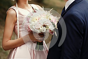 Luxury bride and groom holding hands and gorgeous pink and white