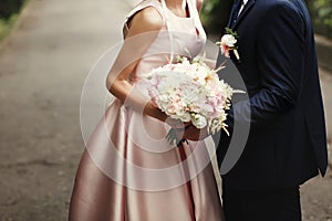 Luxury bride and groom holding hands and gorgeous pink and white