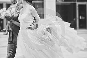 Luxury bride holding a flying dress and walking