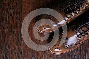 Luxury brown shoes on wood background.