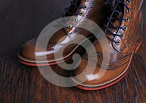 Luxury brown shoes on wood background.