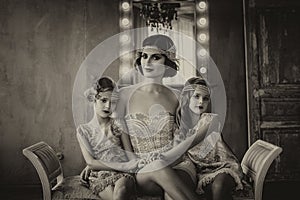Luxury brunette and two baby girls in retro style