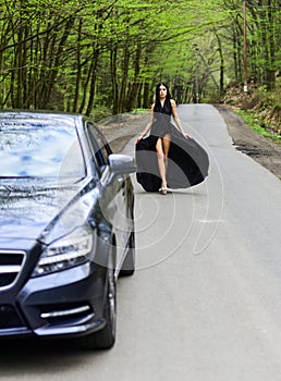 Luxury car. Auto and pretty sexy woman at road. Travel concept. Traveling and vacation. Transport concept. Travel by car