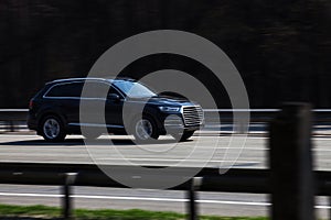 Luxury car black Audi speeding on empty highway