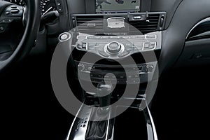 Luxury car inside. Interior of prestige modern car. Automatic transmission gear shift. Black perforated leather cockpit. Media
