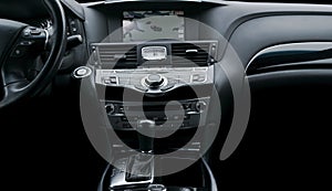 Luxury car inside. Interior of prestige modern car. Automatic transmission gear shift. Black perforated leather cockpit. Media
