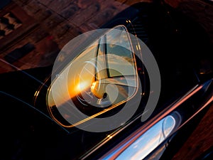 Luxury car mirror with sunset reflection