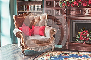 Luxury classic interior of home library. Sitting room with bookshelf, books, arm chair, sofa and fireplace