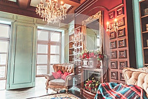 Luxury classic interior of home library. Sitting room with bookshelf, books, arm chair, sofa and fireplace