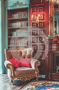 Luxury classic interior of home library. Sitting room with bookshelf, books, arm chair, sofa and fireplace