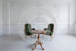 Luxury clean bright white interior with a old antique vintage green chairs over wall design bas-relief stucco mouldings